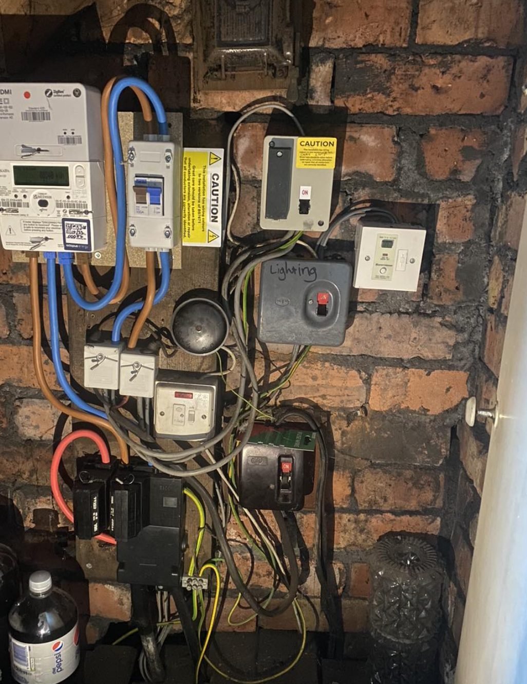 Old rewireable fuse box and henley blocks beside an electricity meter